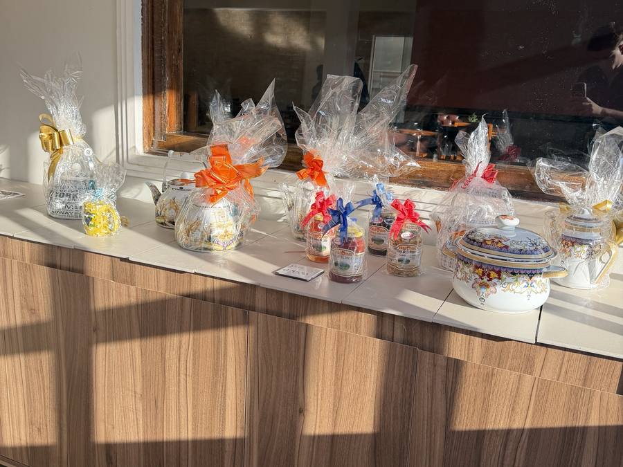 Balcão da entrada com potes de doce caseiro e chaleiras esmaltadas embrulhadas para presente