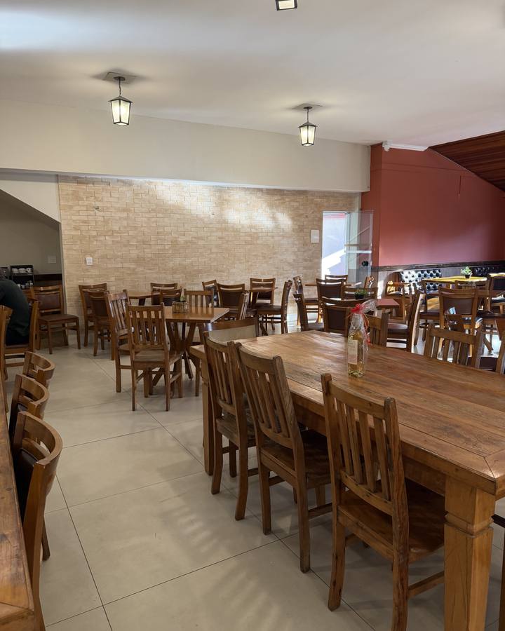Salão com mesa comprida de madeira para grupos