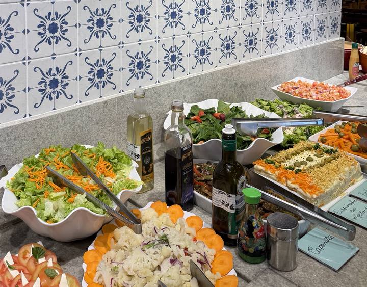 Bancada de saladas com espinafre e morango, caponata e salada de alface com cenoura